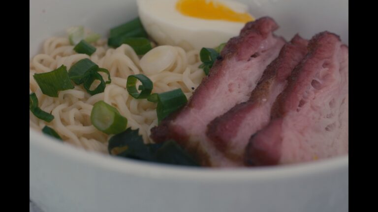 Smoked pork belly ramen in miso broth with a soft egg, seaweed and scallions