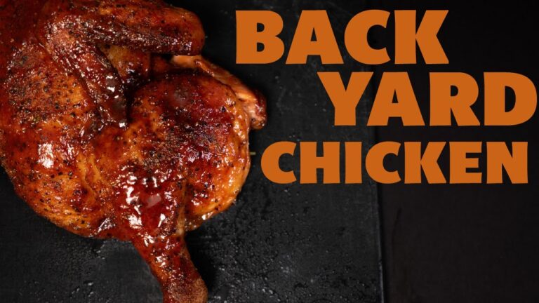 Glazed backyard smoked chicken half sliced on a board